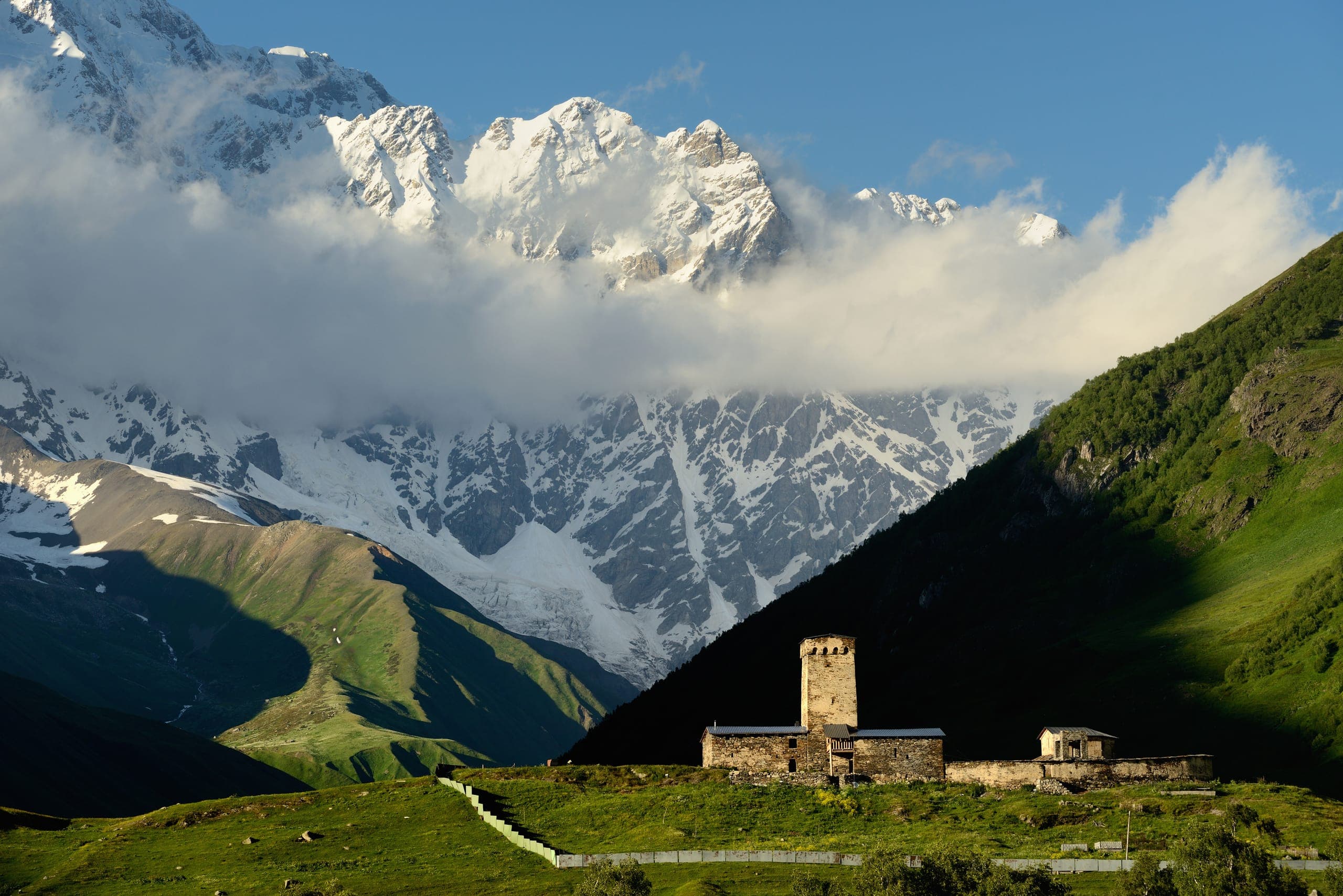 Ancient Svan towers in mountain village with Caucasus Mountains backdrop in Svaneti, Georgia